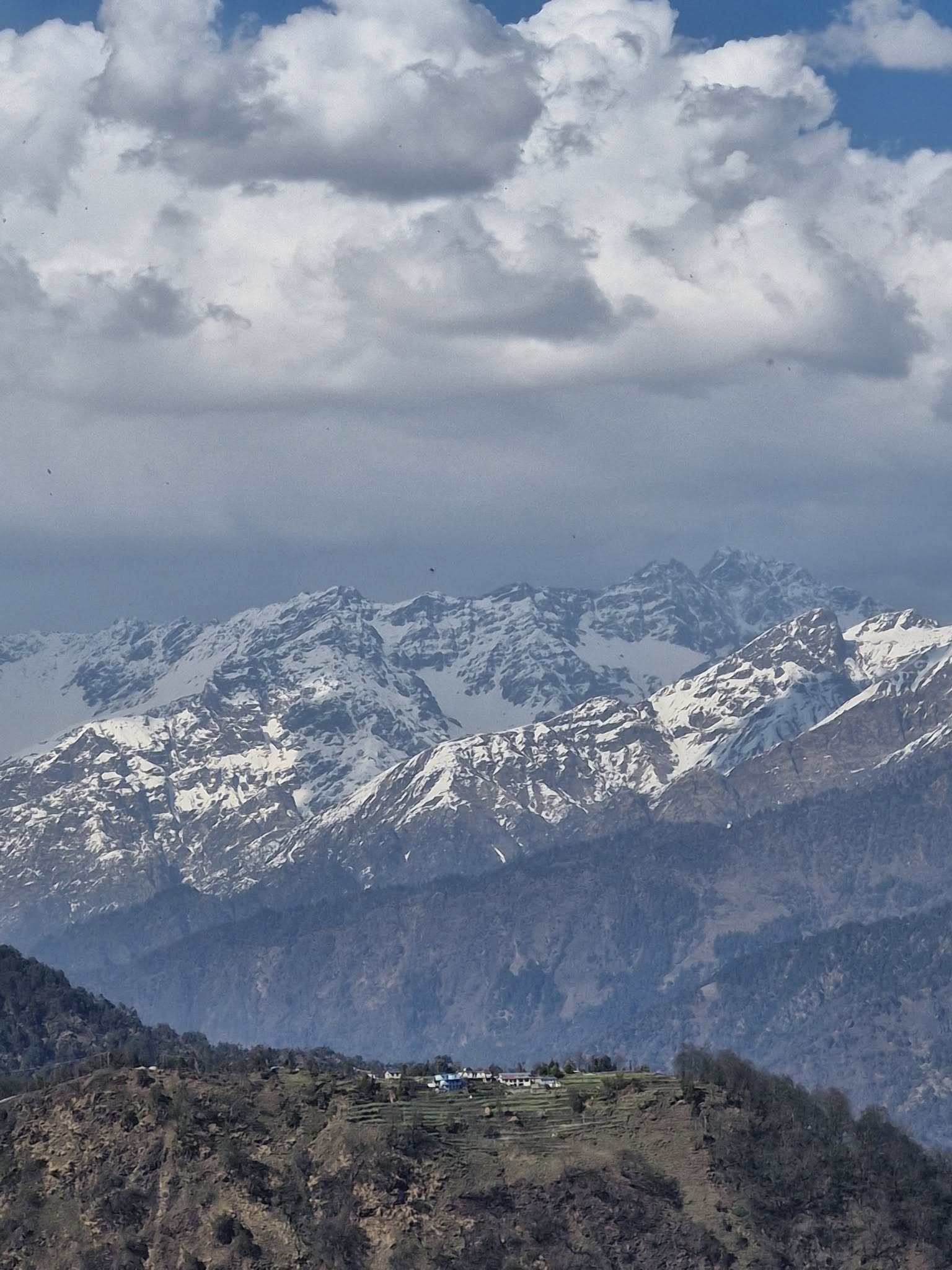 Snow peaks and a ridge village seen on a Liti360 journey